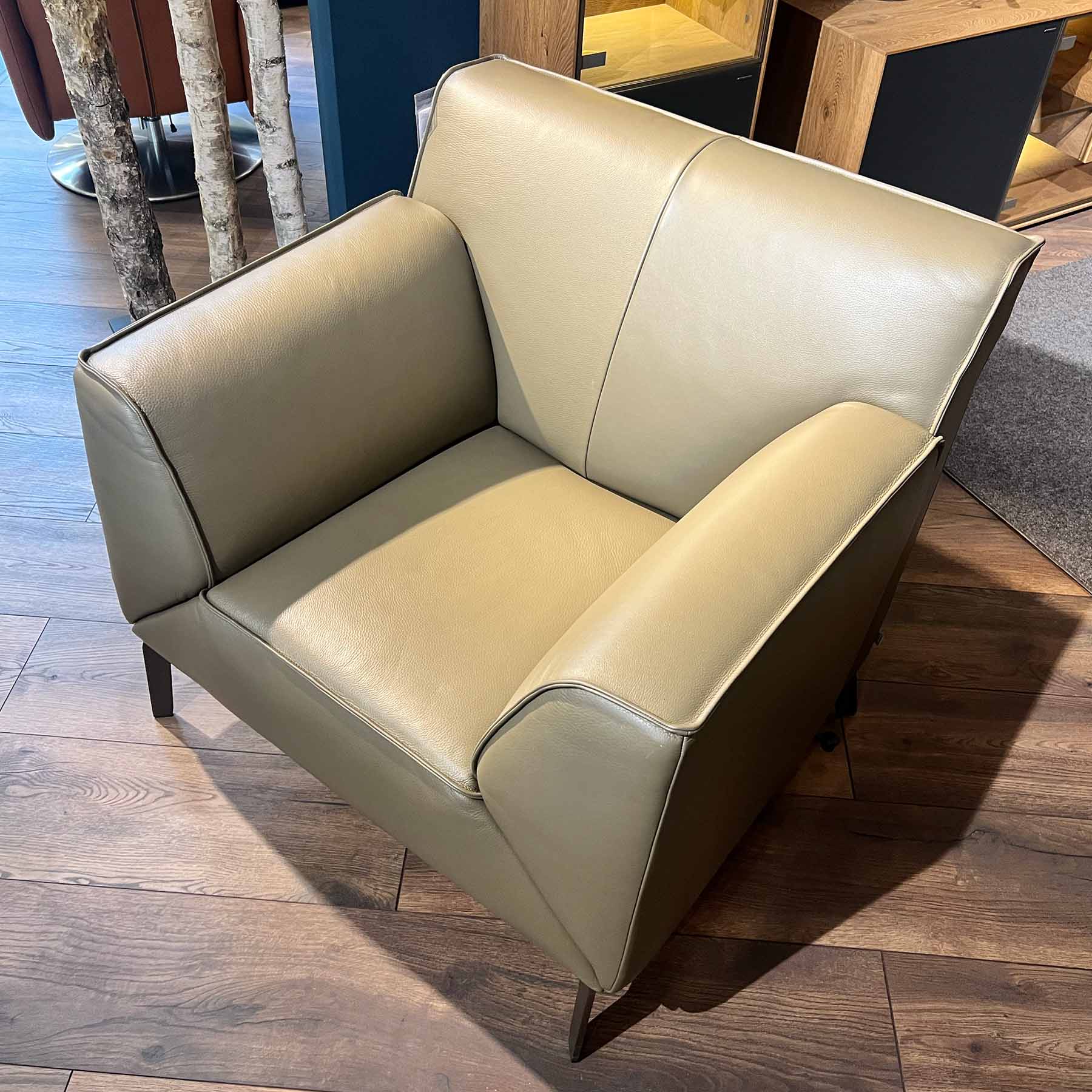 Jori Pacific Pure Sessel 9700-AC93P Designer-Sessel in hellem olivfarbenen Leder auf bronzefarbenen Füßen.