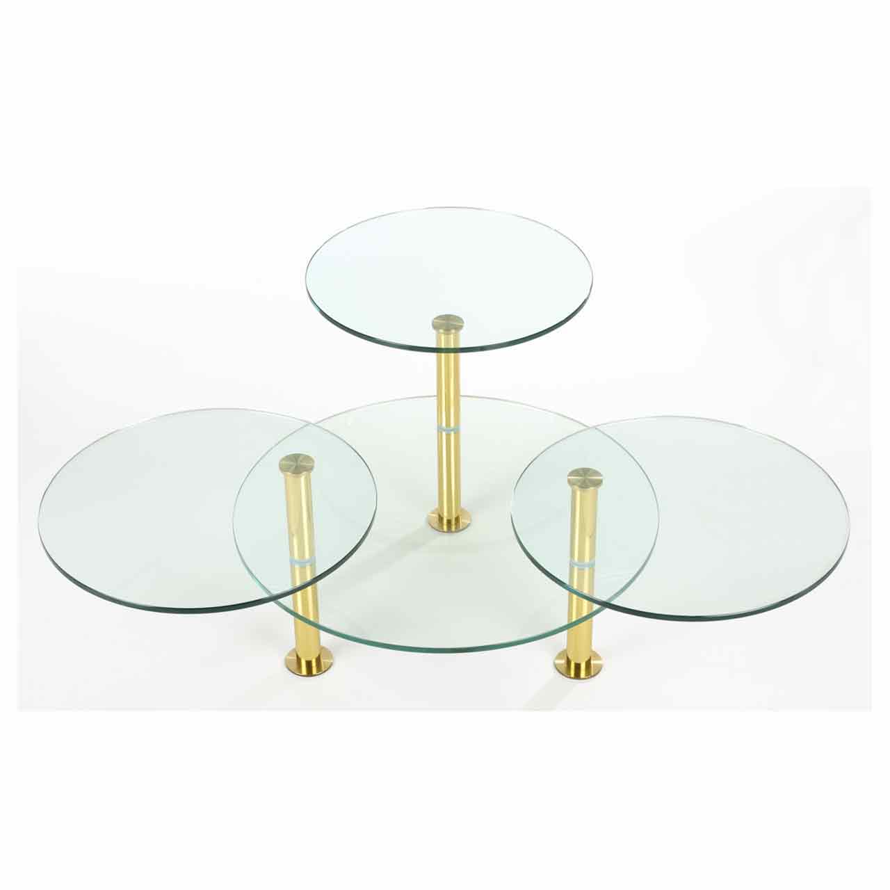 Ronald Schmitt - Couchtisch Gironda K75 Couchtisch besteht aus drei messingfarbenen Säulen, an denen unten eine große runde Glasplatte und weiter oben drei kleine runde Platten montiert sind.