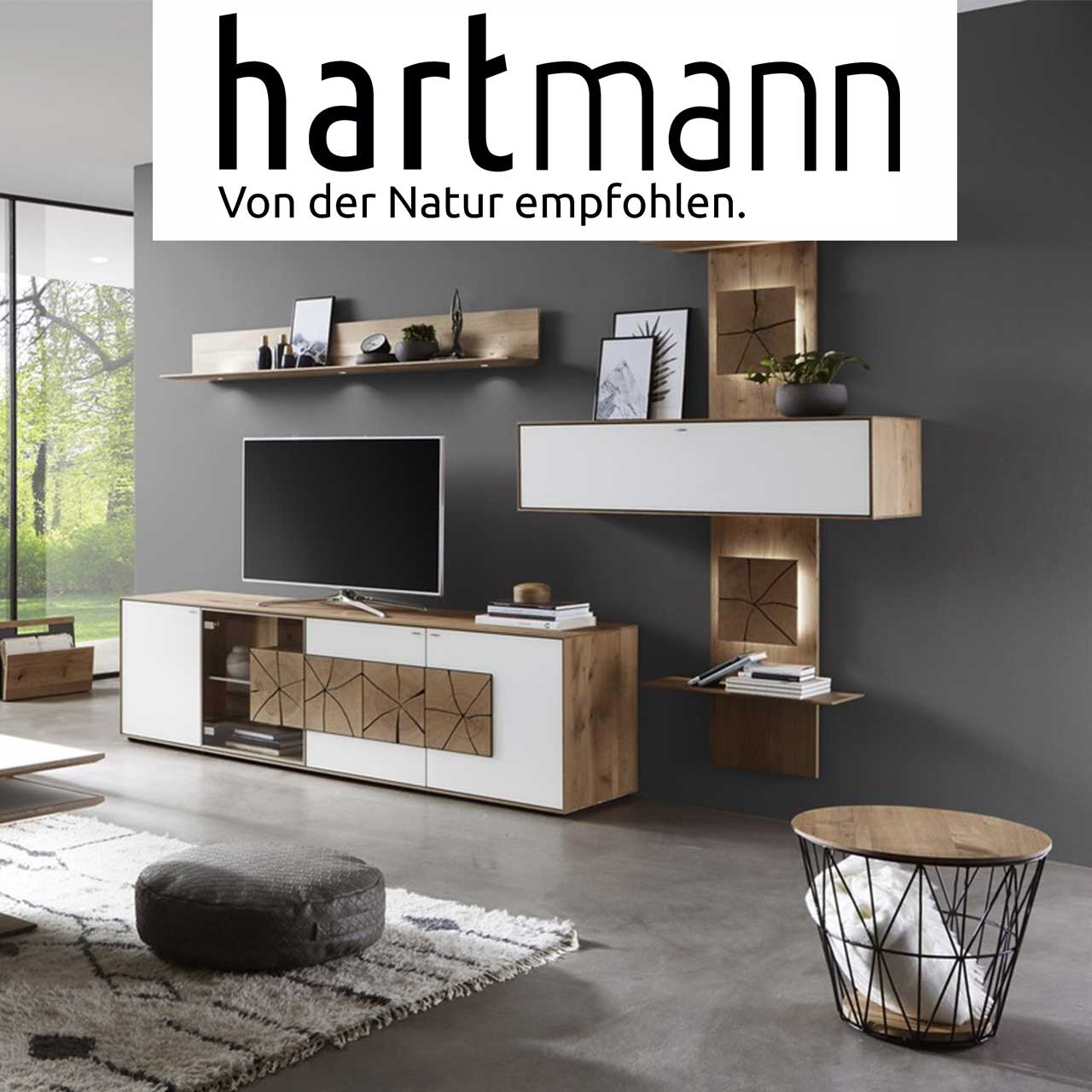 MH_Markenshops_hartmann Ambientebild Wohnzimmer der Marke hartmann in weiß und naturbelassenem Holz mit Spaltholzakzenten.