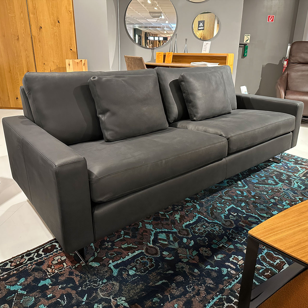 Zweisitzer-Sofa aus schwarzem Leder leicht seitlich fotografiert.