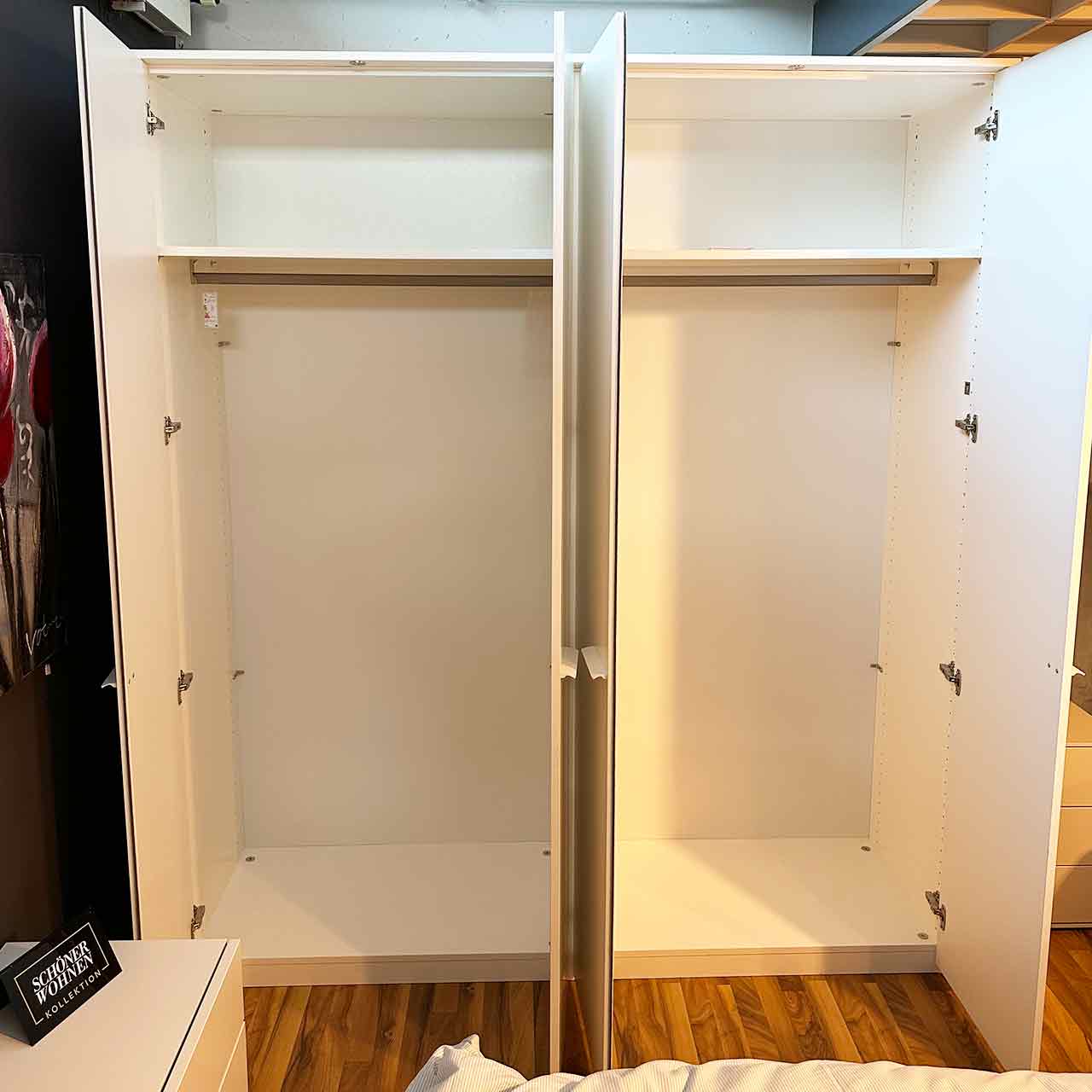 Schrank mit geöffneten Türen. Klassische Einteilung, oben ein Einlegeboden, darunter die Kleiderstange.