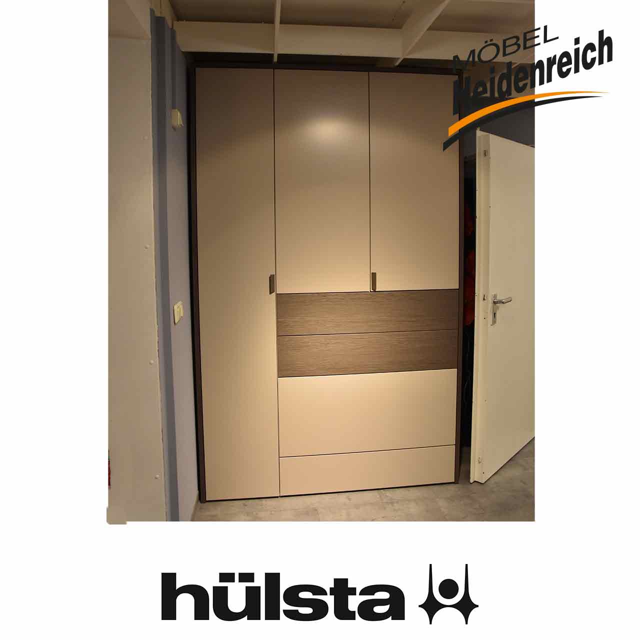 Hülsta Multi-Forma - Kleiderschrank mit Passepartout Hellgrauer Kleiderschrank, links hohe Tür, daneben zwei kurze Türen über zwei grauen Holz-Schubladen über zwei hellgrauen Schubladen.
