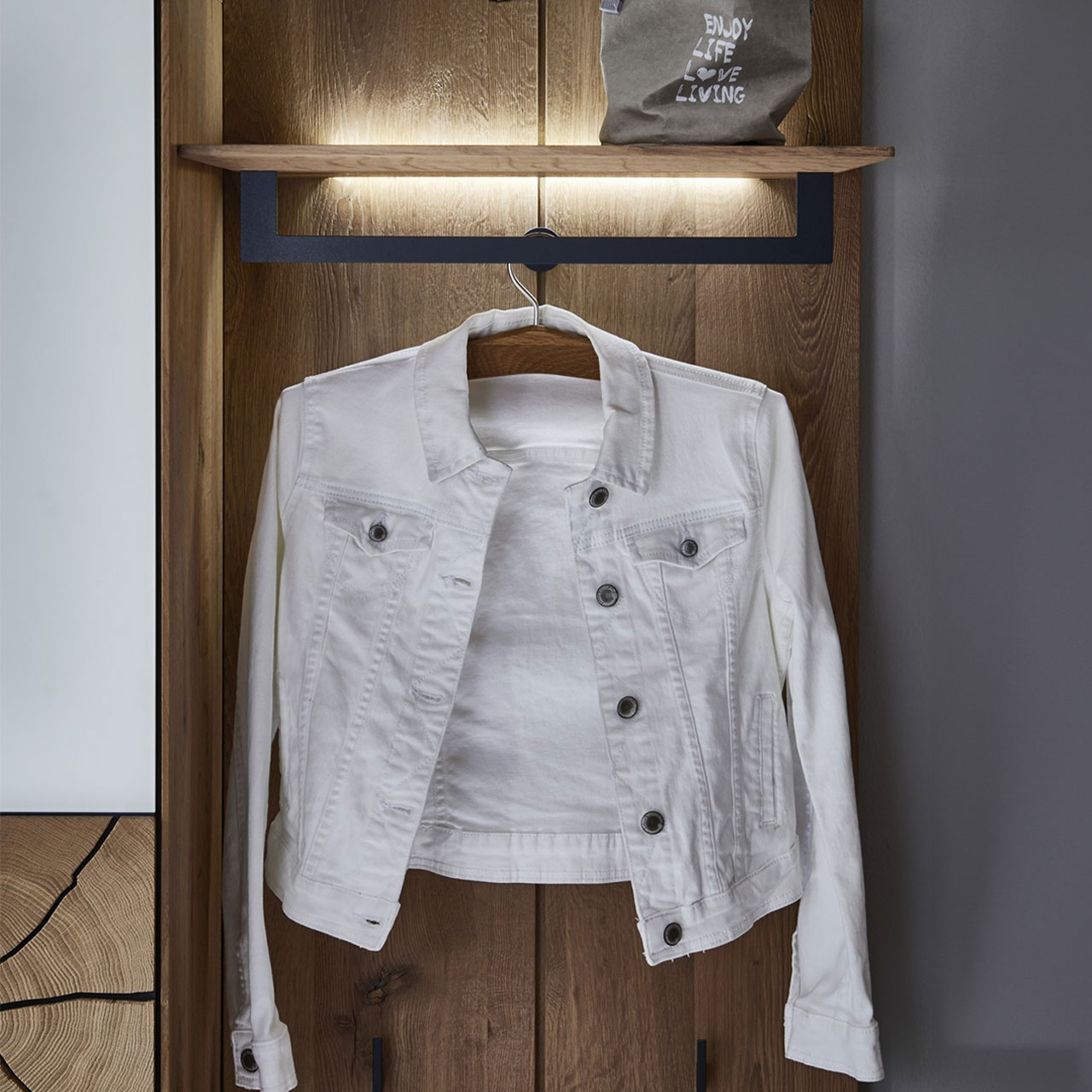 MH_Kategorie_Garderobenelement Hochwertiges Garderobenelement aus Holz mit einer weißen Jeansjacke.