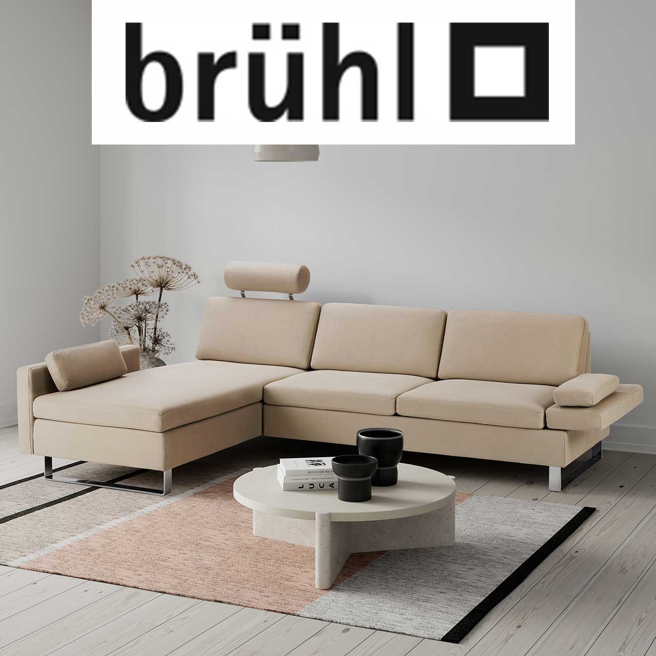 MH_Markenshops_bruehl Ambientebild Wohnzimmer der Marke brühl, bestehend aus einem Sofa 3 Sitzer in hellem Beige und Designercouchtisch in offwhite.