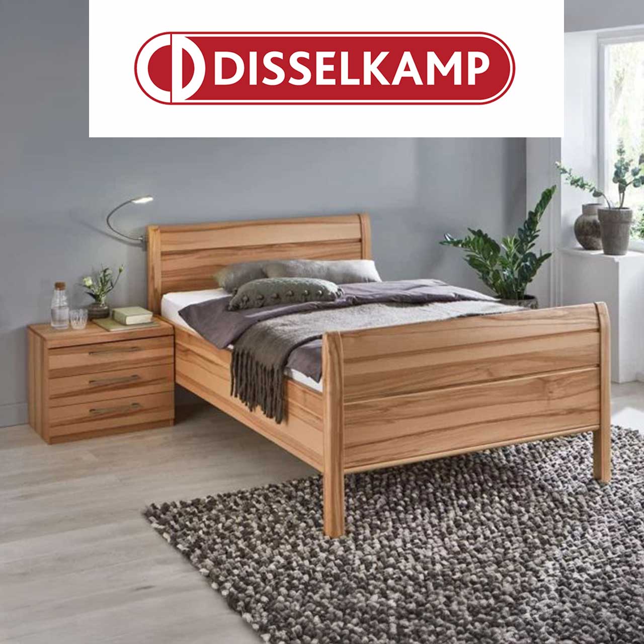 Bett aus Holz mit Stollenkopfteil und Fußteil, daneben Nachttisch mit drei Schubladen