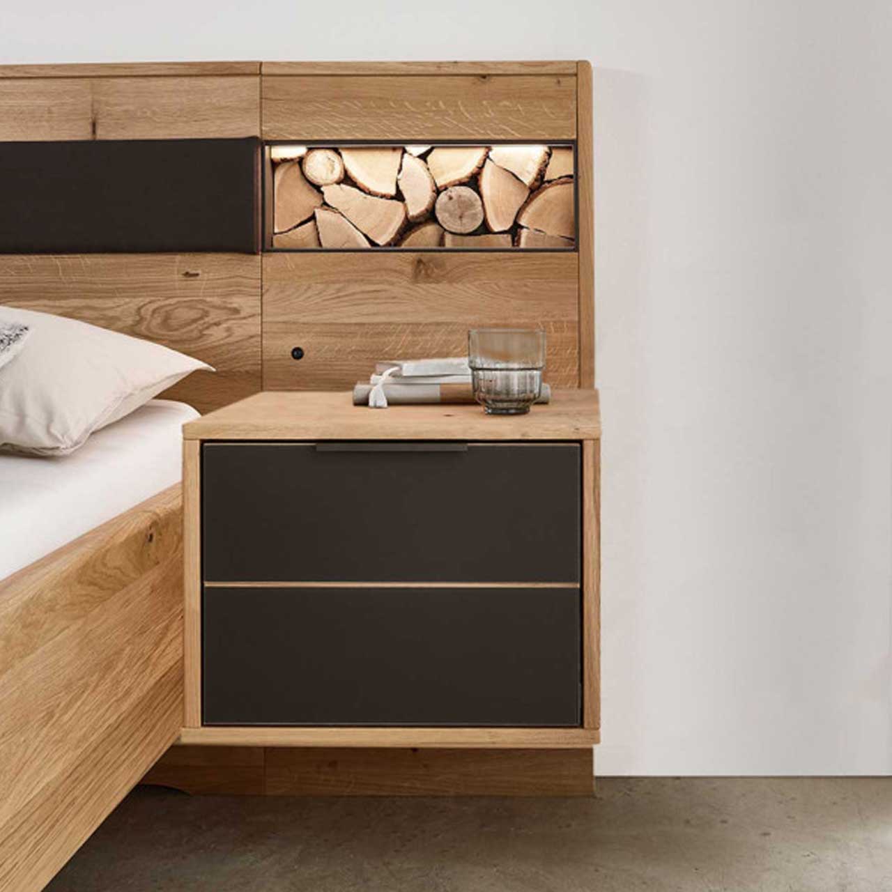 MH_Schlafzimmer_Konsolen Ambientebild- Ausschnitt einer Schlaflandschaft mit Fokus auf Hängekonsole aus Holz mit zwei Schubladen in Anthrazit.