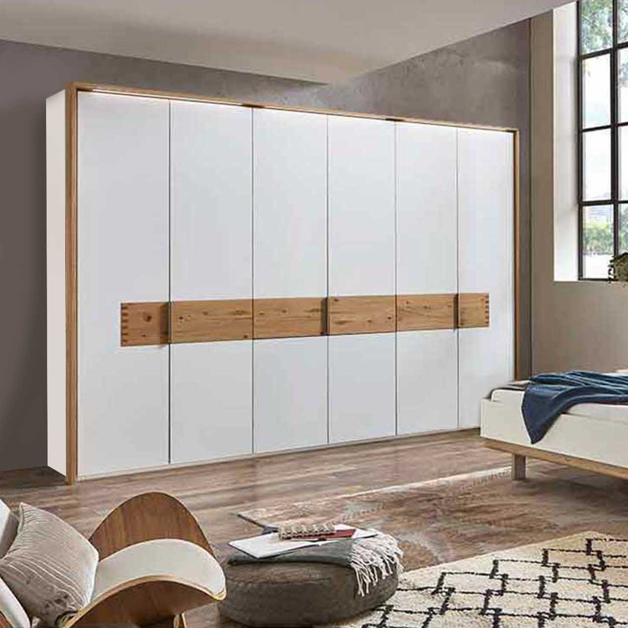 MH_Schlafzimmer_Kleiderschrank Ambientebild mit Fokus auf einen weißen, sechstürigen  Kleiderschrank mit Holzakzenten.