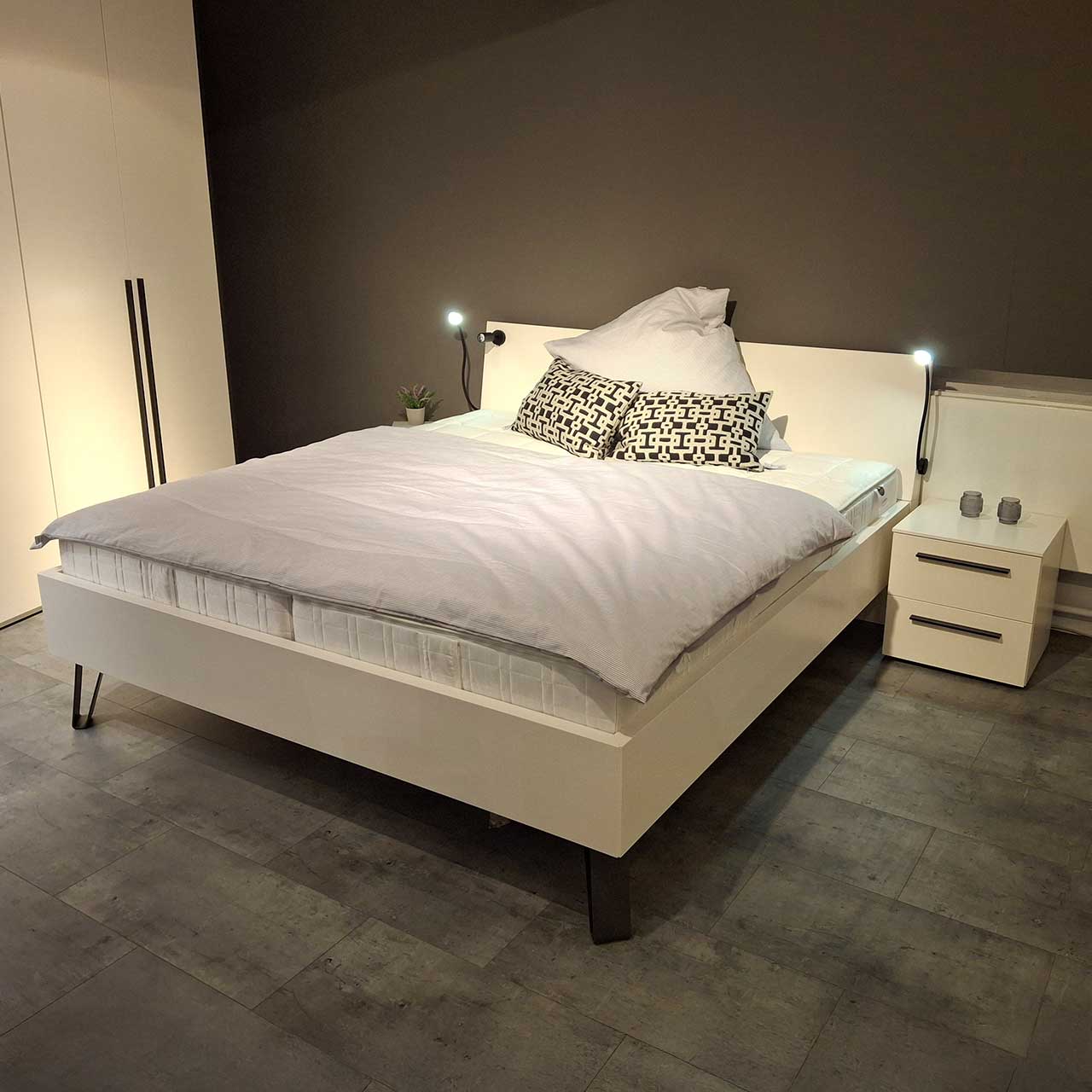 Loddenkemper Bettanlage 700 Weißes Doppelbett mit integrierter Beleuchtung am Kopfteil und Konsolen mit zwei Schuladen.