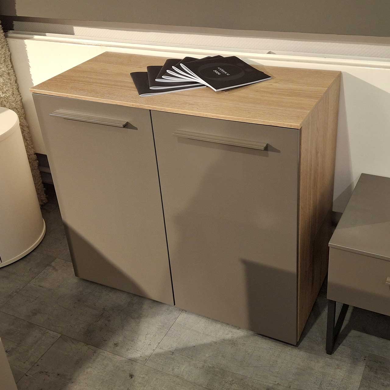 Loddenkemper - Kommode Terrabraun Eiche Kommode mit Korpus aus hellem Holz. Zwei Türen mit brauner Front und länglichen Griffen.