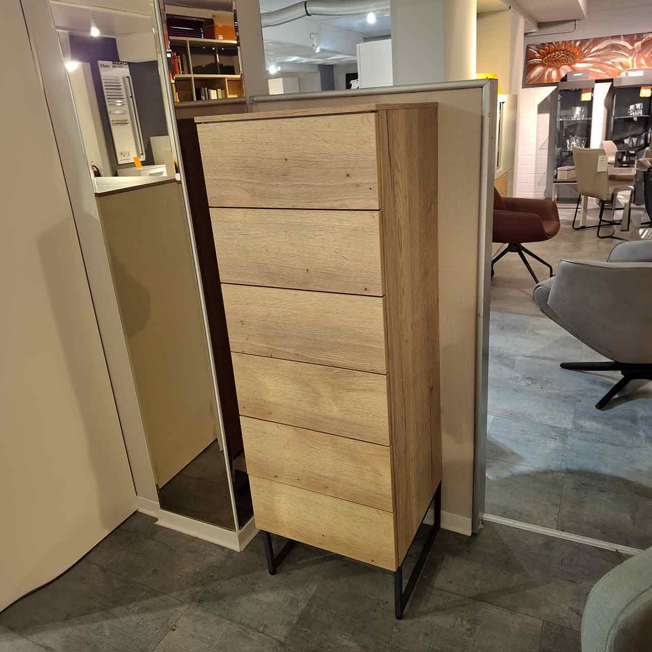 Loddenkemper - Kommode maxx 600 Balkeneiche Hohe schmale Kommode aus heller Eiche mit sechs grifflosen Schubkästen. Steht auf zwei grauen Kufen.