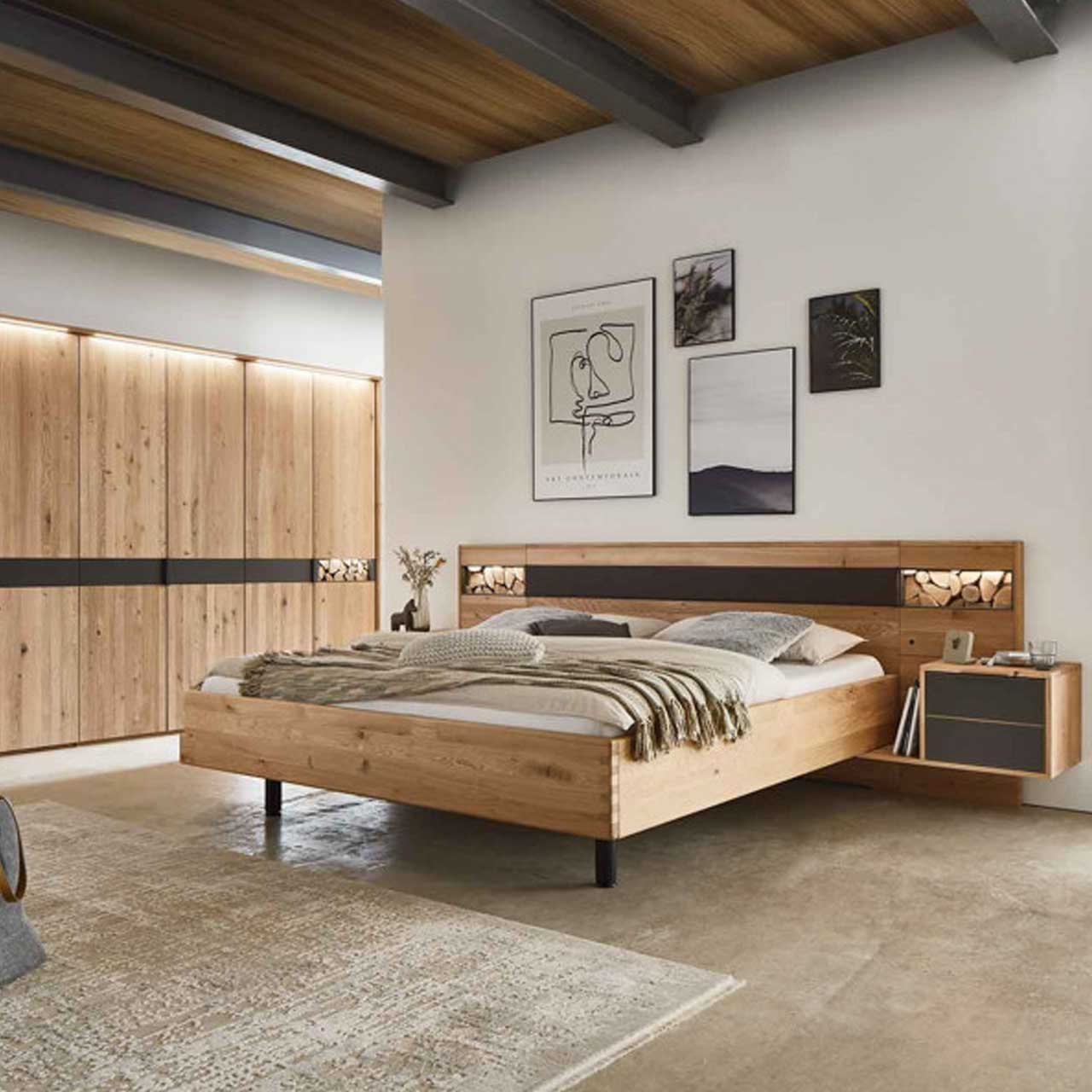 MH_Schlafzimmer_Komplettsets Ambientebild Schlafzimmer mit integriertem Einbauschrank aus Holz mit anthrazitfarbenen Akzenten und Details mit Spaltholzoptik und passender Schlaflandschaft aus Holz mit integrierten Nachttischen.