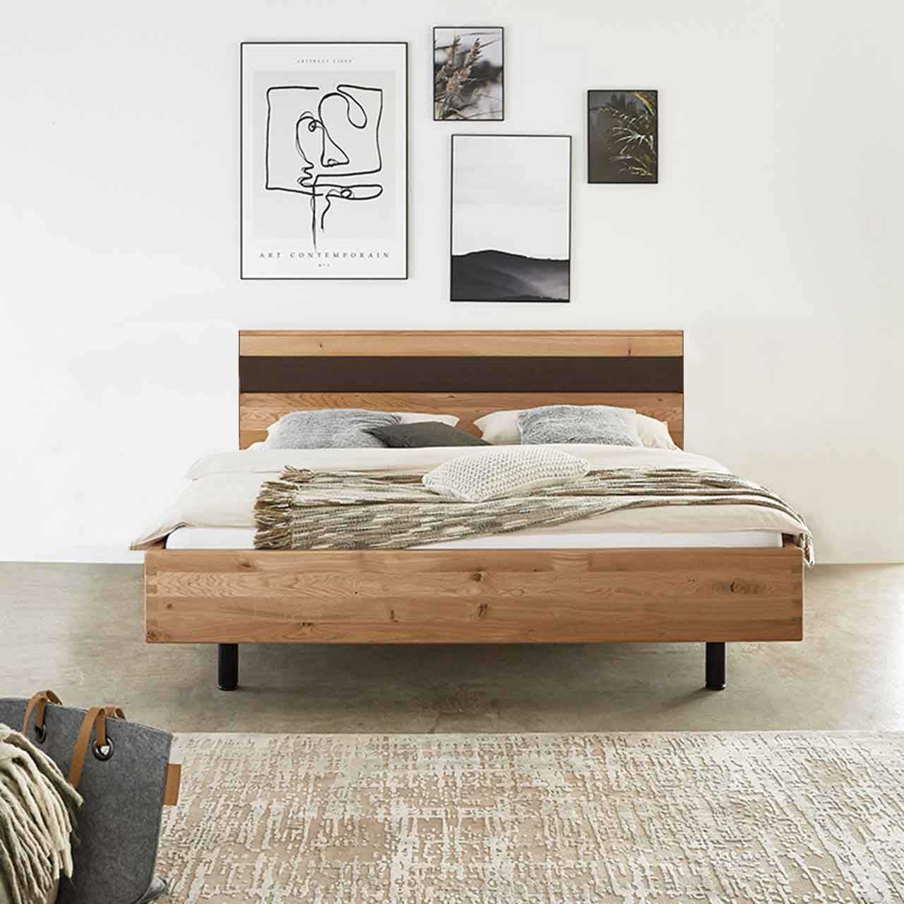 MH_Schlafzimmer_Betten Ambientebild Schlafzimmer mit Fokus auf ein freistehendes Doppelbett aus Holz mit dunkrelbraunem Akzent ein der Rückenlehne.