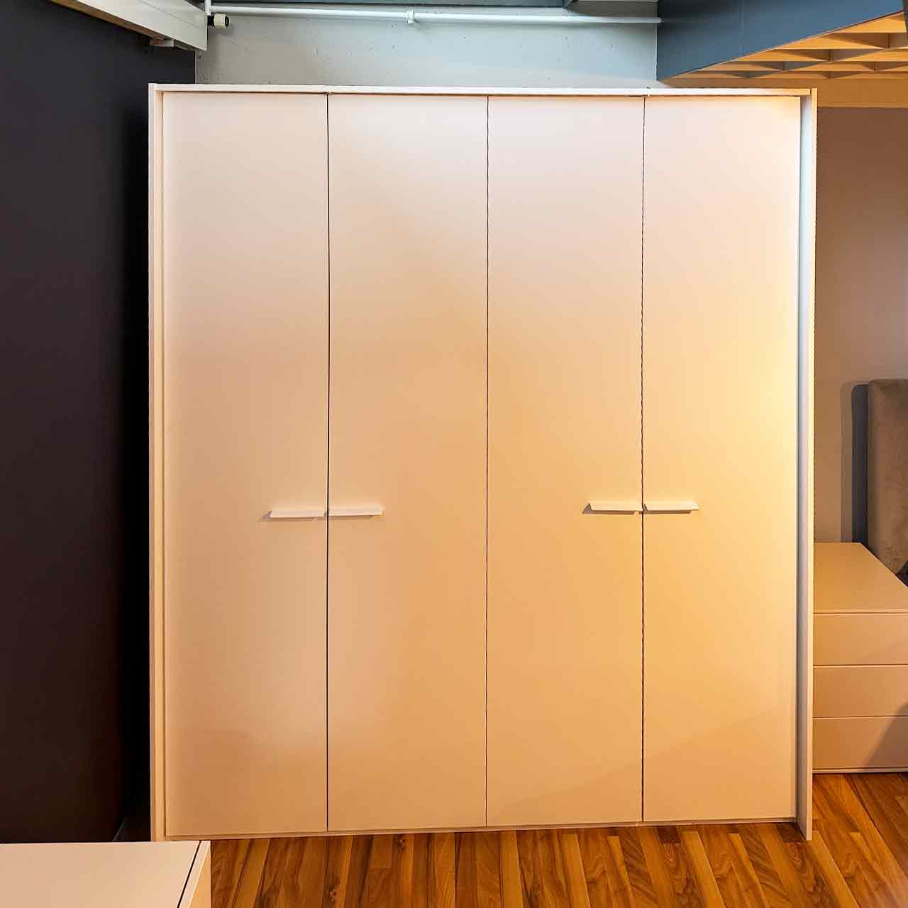 Weißer Kleiderschrank mit vier Türen und umlaufendem Passepartout.