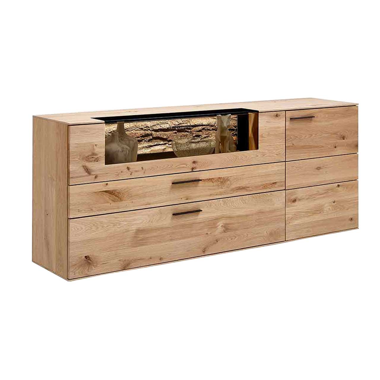 Hartmann Runa - Sideboard 8410-4191 Sideboard aus hellem Holz mit Glasausschnitt links oben, der einen Blick auf eine rustikale Rindenrückwand bietet. Rechts hat das Sideboard eine Tür und unter der Klappe mit Glasausschnitt sind zwei Schubladen.