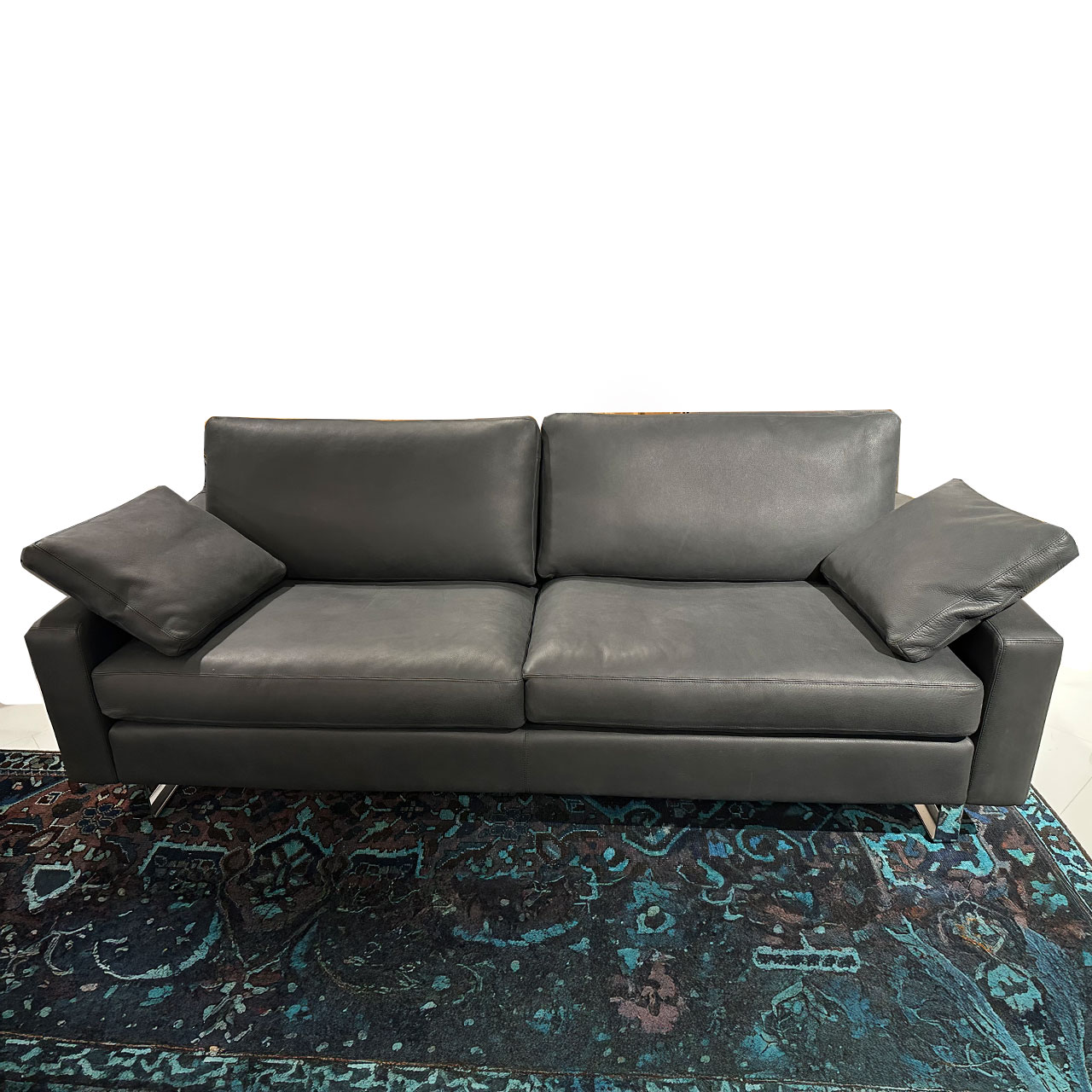 Zweisitzer-Sofa aus schwarzem Leder mit zwei passenden Kissen auf den niedrigen Armlehnen. Glänzende Kufen.