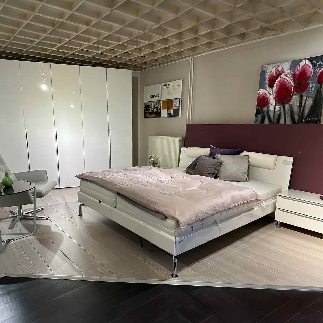 Hülsta Metis - Schlafzimmer weiß Weißes Schlafzimmer bestehend aus von links nach rechts Kleiderschrank, Bett, Nachttische, genauere Beschreibung in den Folgebildern.