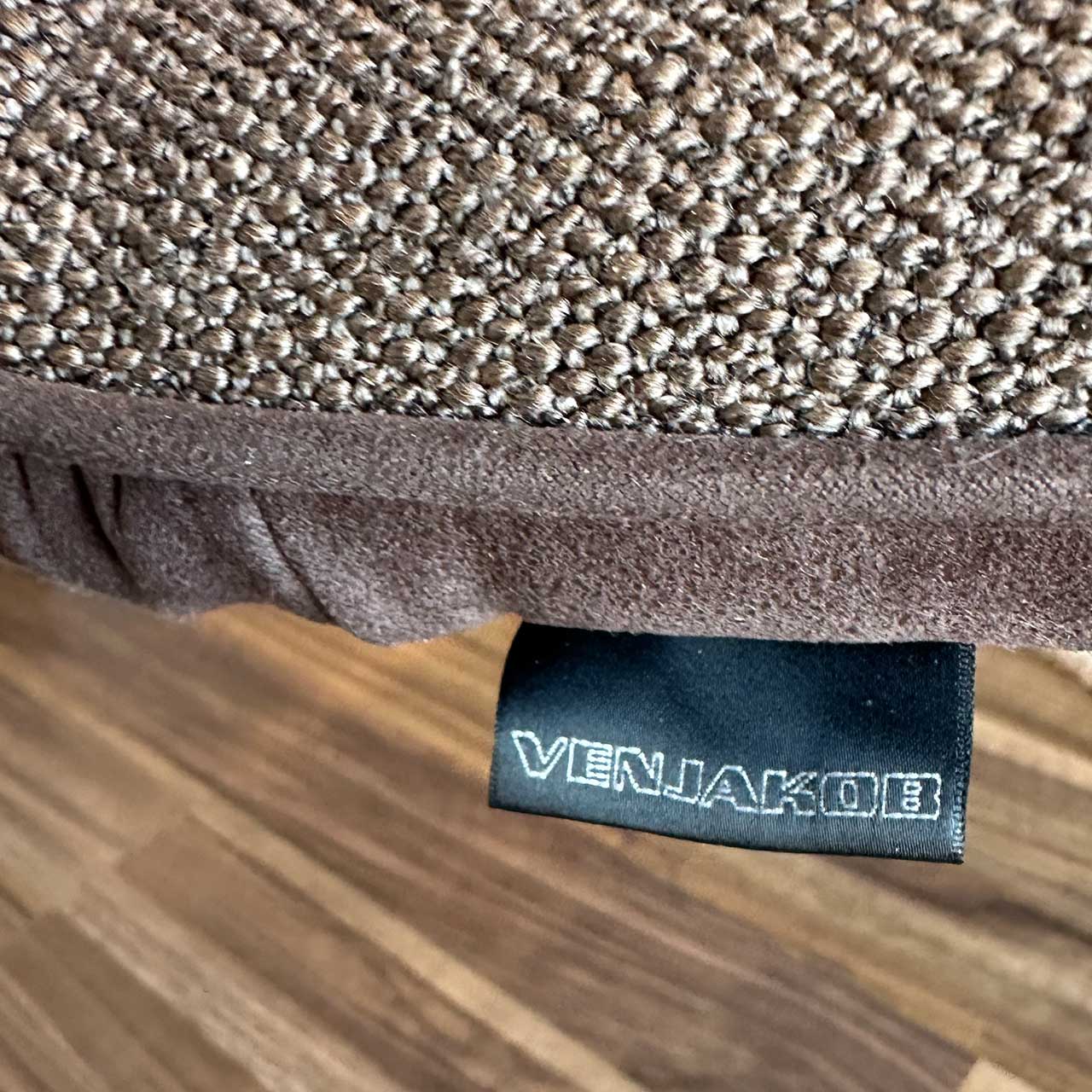 Detailbild des Stuhl-Stoffes. Oben grob gewebt, unten und hinten velourartig braun. Label Venjakob ist sichtbar.