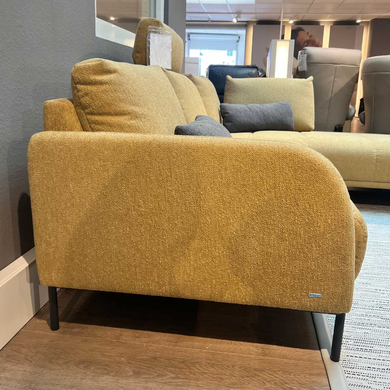 Activineo - Ecksofa Bounty - Seitenaufnahme Gleiches Sofa von der Seite. Die vorne abgerundete Armlehne ist im Fokus.